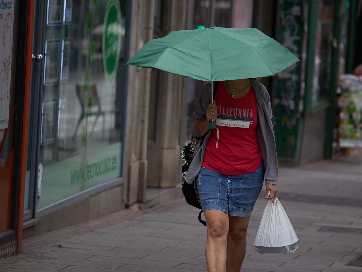 Foto: Una mujer se protege de la lluvia en Madrid. (Europa Press/Jesús Hellín)