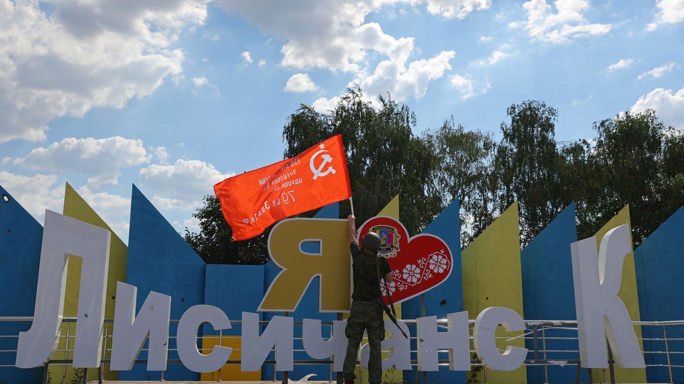 Foto: Un militante de las tropas prorrusas en el Donbás, con una bandera soviética. (Reuters/Alexander Ermochenko)