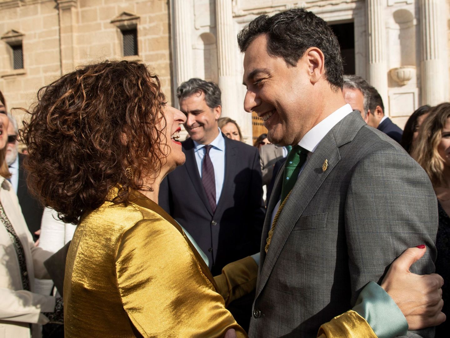 La ministra de Hacienda y portavoz del Gobierno de España, María Jesús Montero (i), saluda al presidente andaluz, Juanma Moreno (d), en una imagen de febrero de 2020. (EFE)