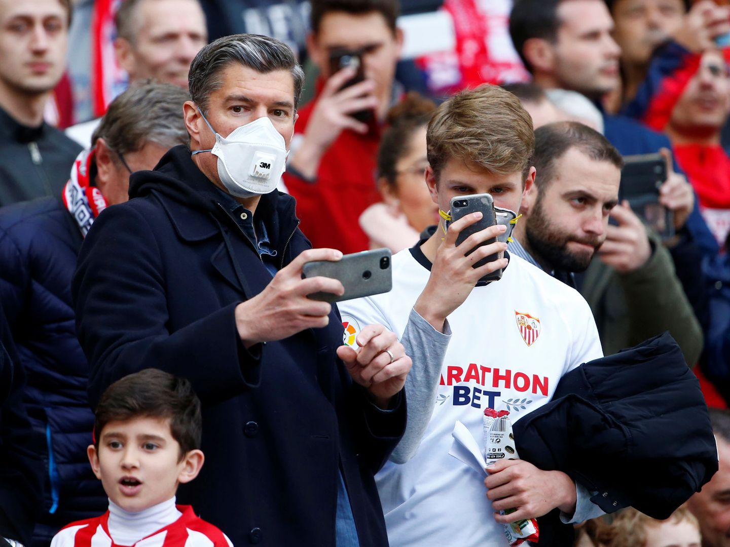 Aficionados del Sevilla Club de Fútbol, con mascarillas. (Reuters)