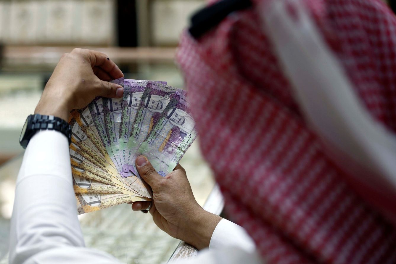 Un cambista saudí exhibe billetes en una casa de cambio en Riad, el 27 de julio de 2017. (Reuters)