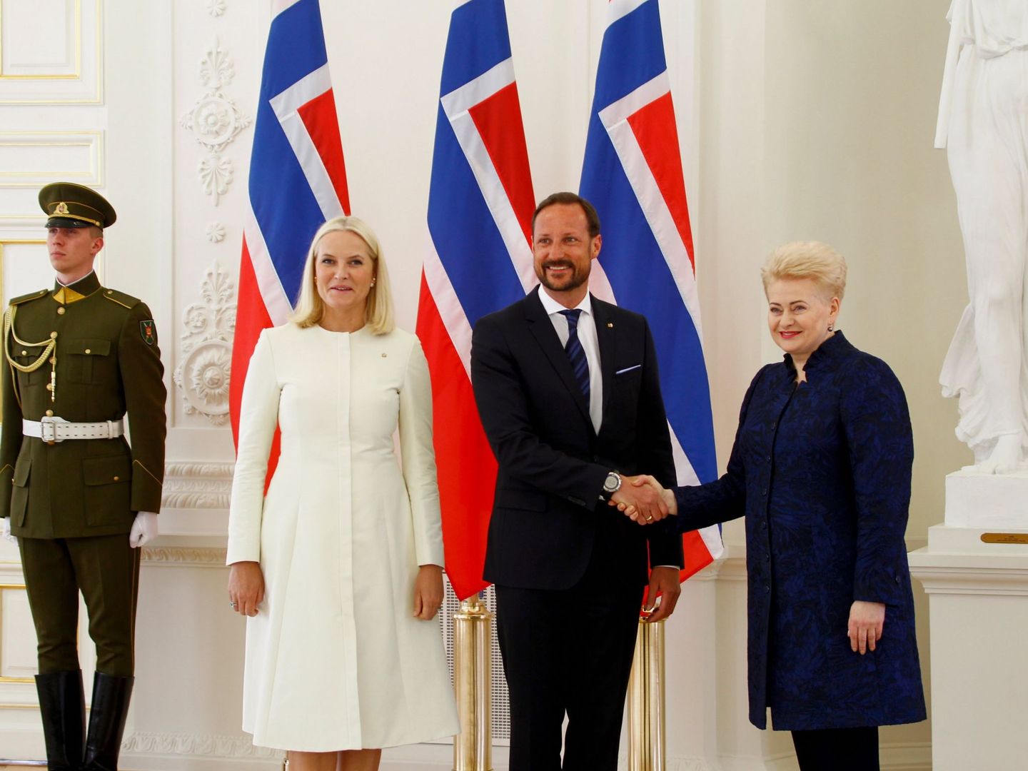 La presidenta lituana estrecha la mano del príncipe heredero Haakon. (EFE)