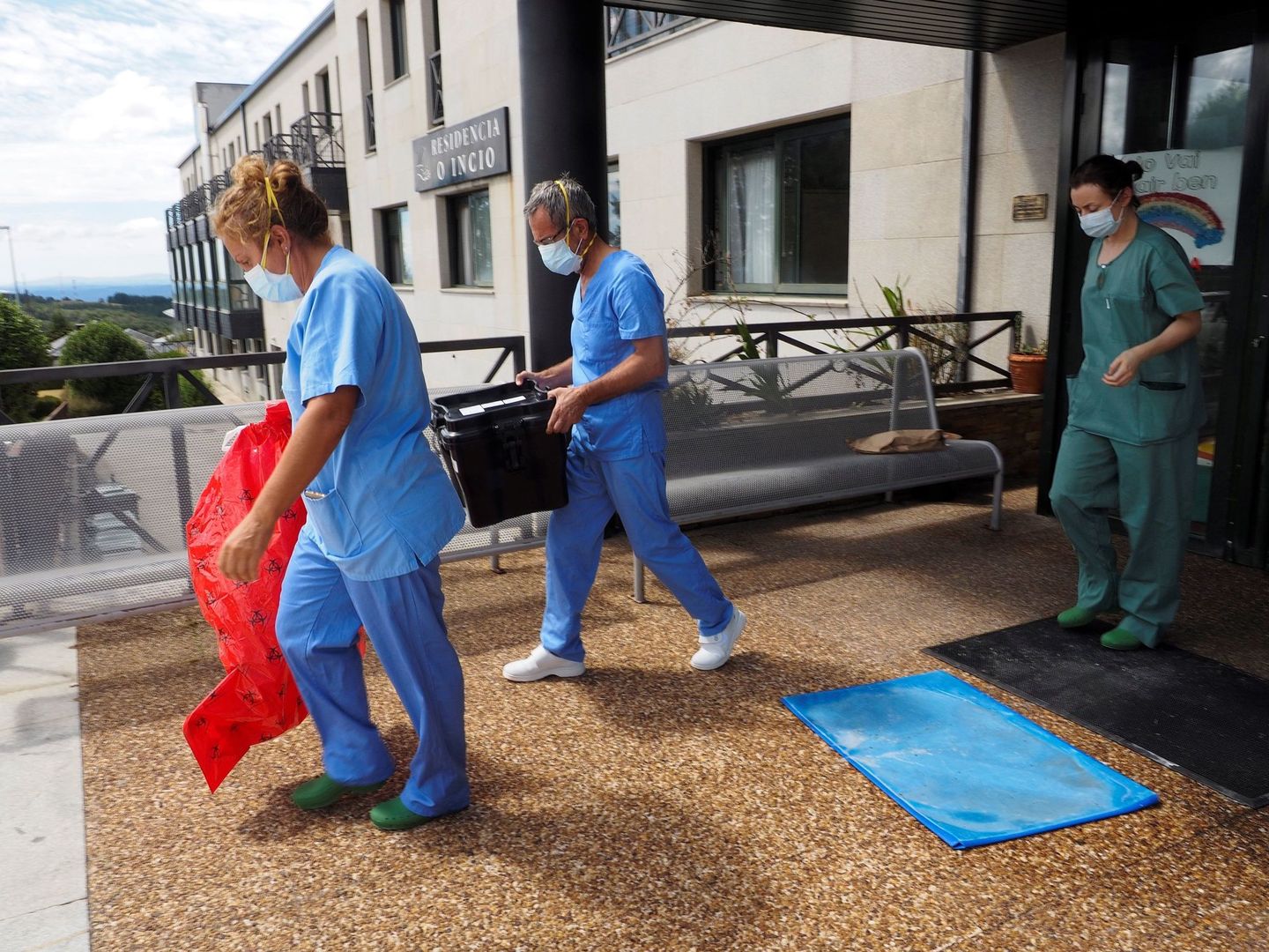 Trabajadores sanitarios salen de la residencia O Incio, en Lugo. (EFE)