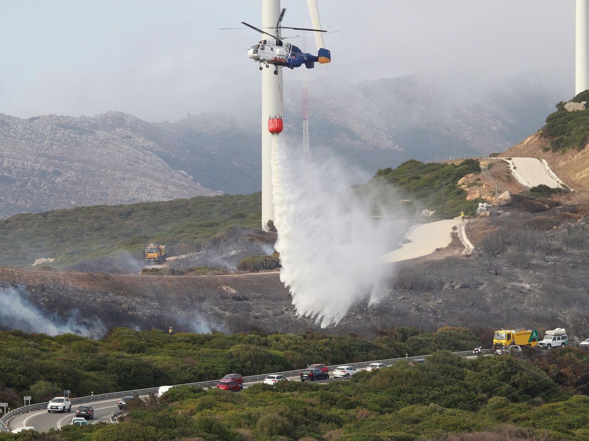 Foto: Un helicóptero echa agua sobre una zona donde se ha producido un incendio forestal, en una imagen de archivo. (EFE/A. Carrasco Ragel)