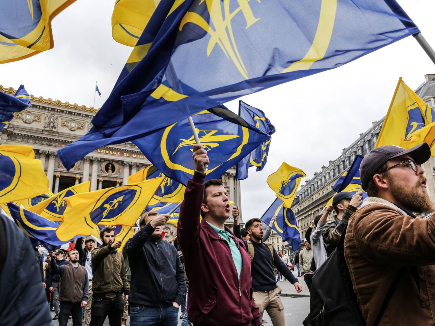 Jóvenes militantes de Acción Francesa recorren las calles de Parías con las banderas de la flor de lis. (Teresa Suárez)