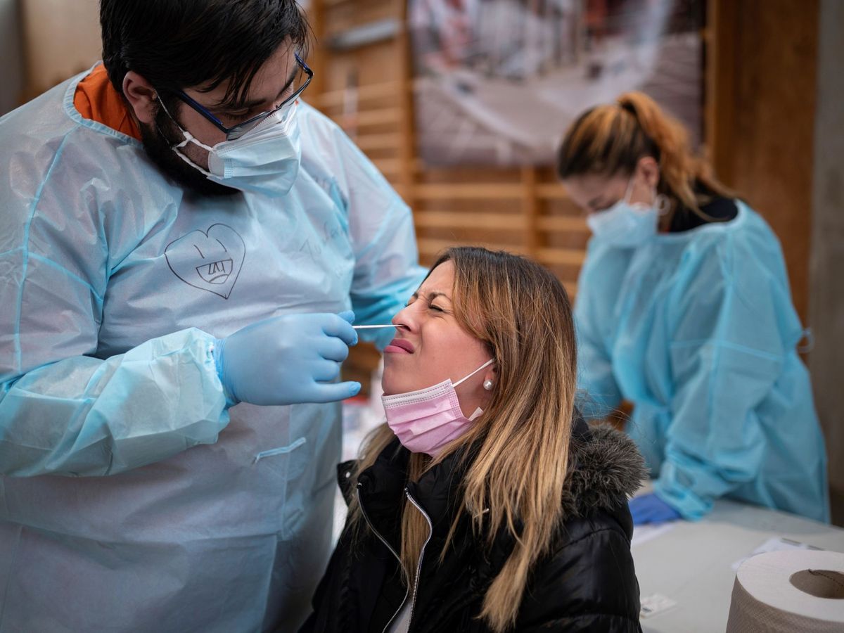 Foto: Un sanitario hace un test de antígenos a una joven en la Comunidad de Madrid. (EFE/Fernando Villar)