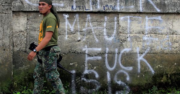 Foto: Un soldado filipino pasa frente a un antiguo grafitti de apoyo a los yihadistas, modificado por un desconocido, en Marawi, el 2 de junio de 2017. (Reuters)