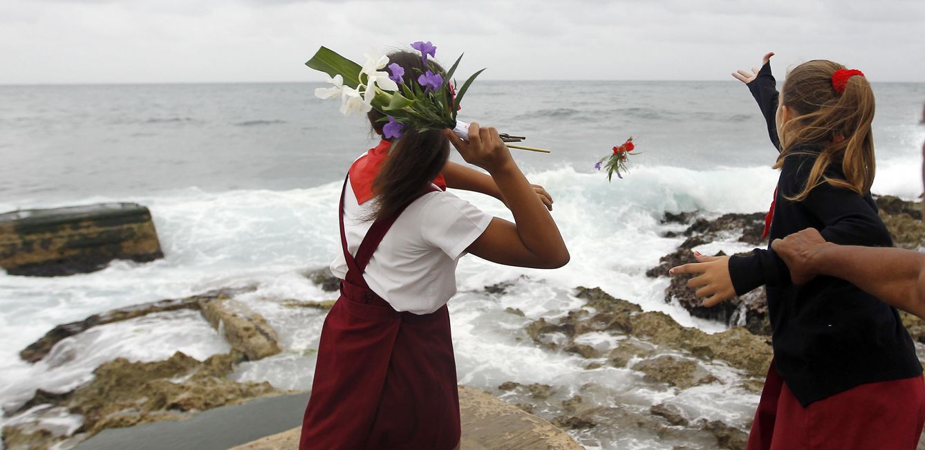Niños cubanos arrojan flores al mar en homenaje Camilo Cienfuegos. (EFE)