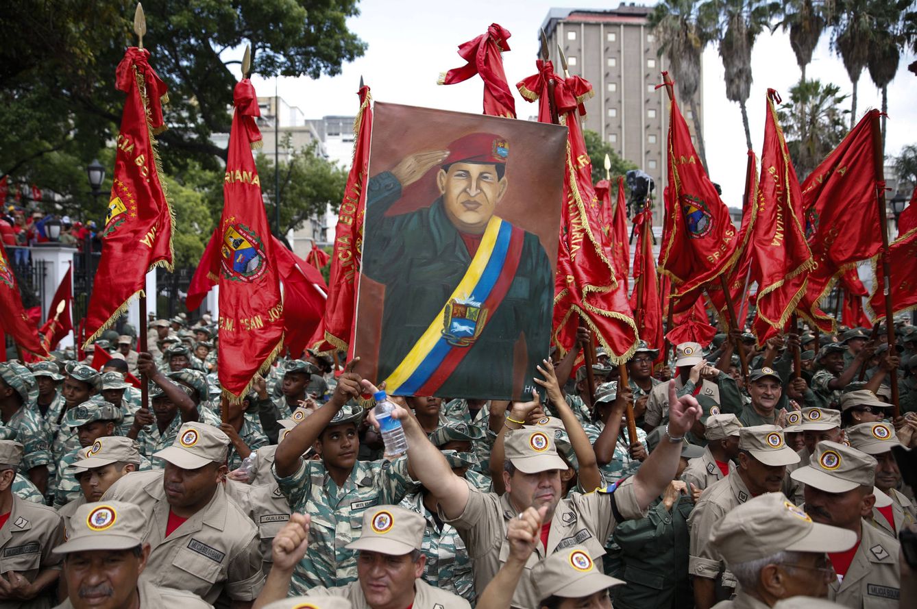 Miembros de una milicia sostienen un retrato del difunto Hugo Chávez durante una ceremonia en Caracas (Reuters).