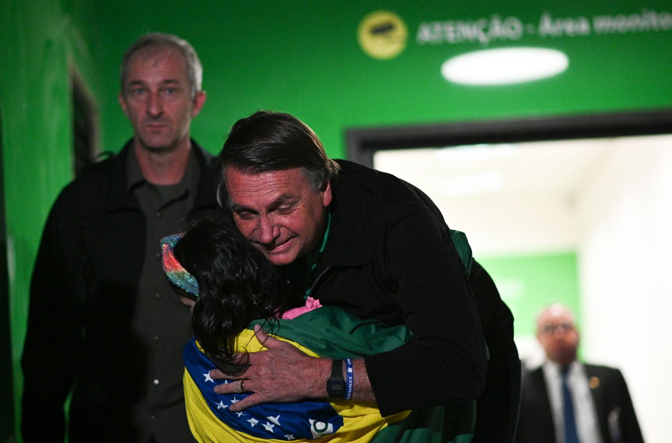 El expresidente de Brasil, Jair Bolsonaro, saluda una seguidora mientras sale del aeropuerto en Brasilia (Brasil). (EFE/Andre Borges)