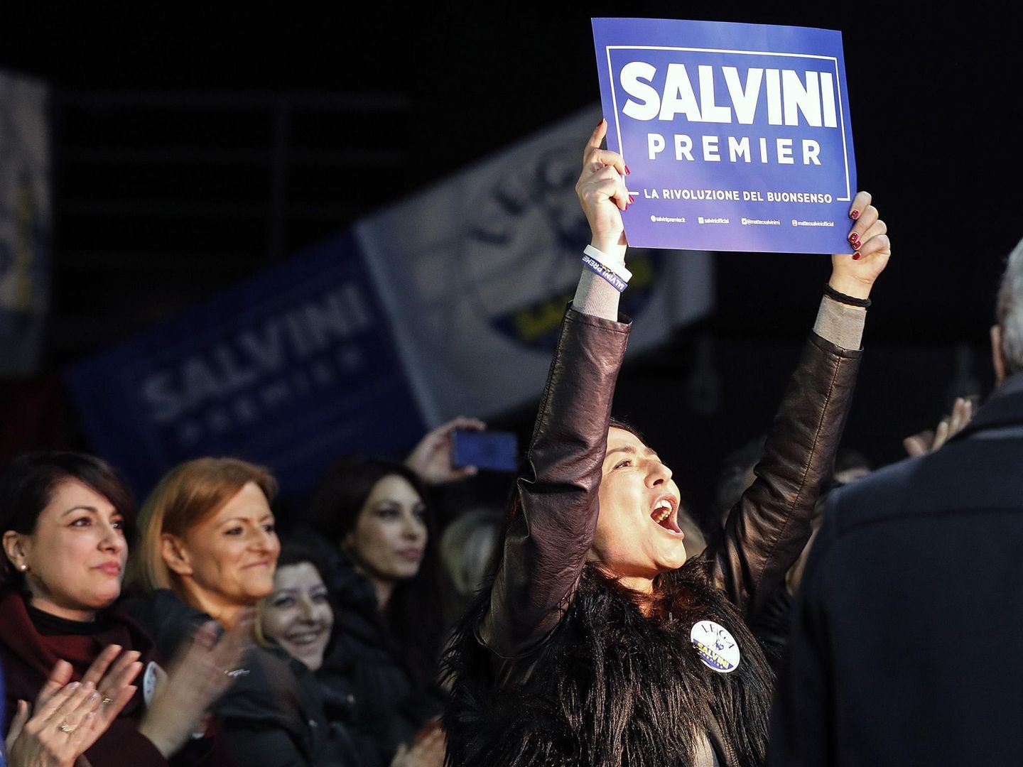 Una mujer sujeta un cartel de apoyo al candidato para primer ministro Matteo Salvini durante un mitin electoral en Roma. (EFE)