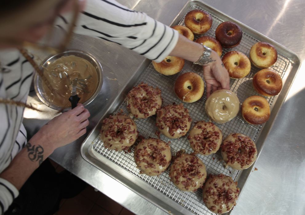 Foto: Una panadera prepara unos donuts veganos y libres de gluten, pero con bacón, en una tienda de Los Ángeles. (Reuters)