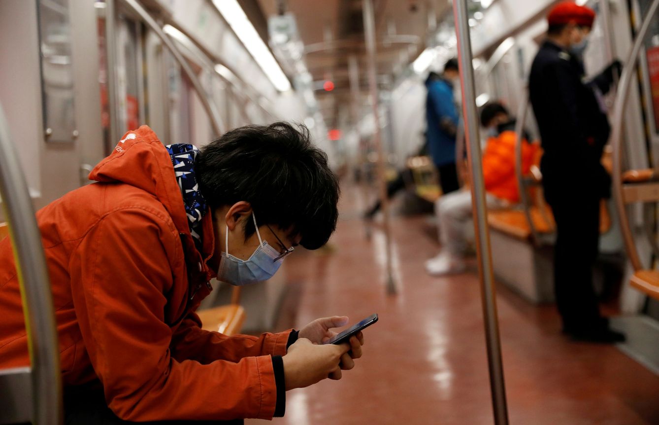 Un hombre ataviado con mascarilla mira su móvil en Pekín. (Reuters)