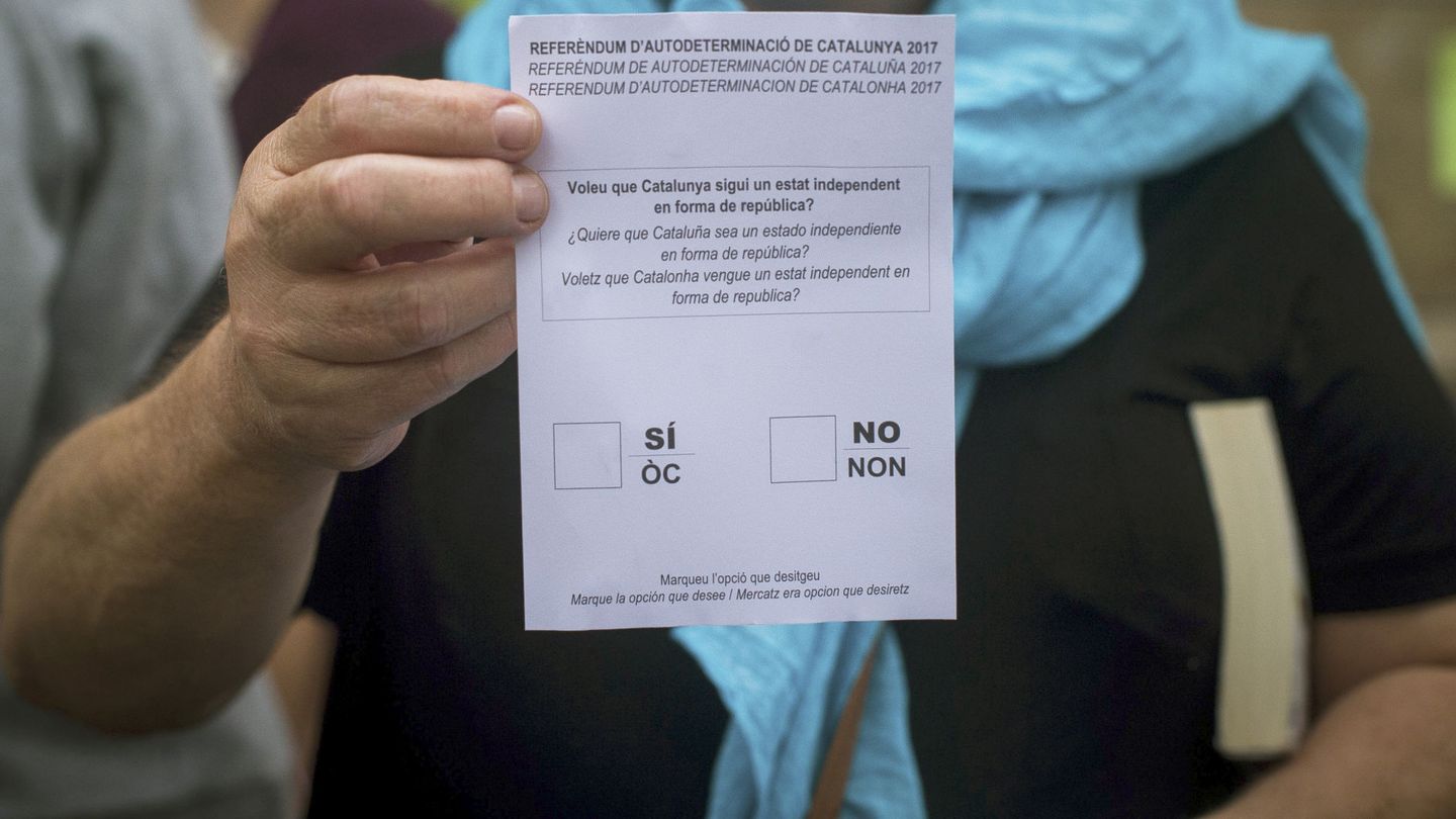 Una mujer muestra una papeleta del referéndum del 1-O en un colegio de Barcelona donde se están haciendo actividades para mantenerlo abierto. (EFE)