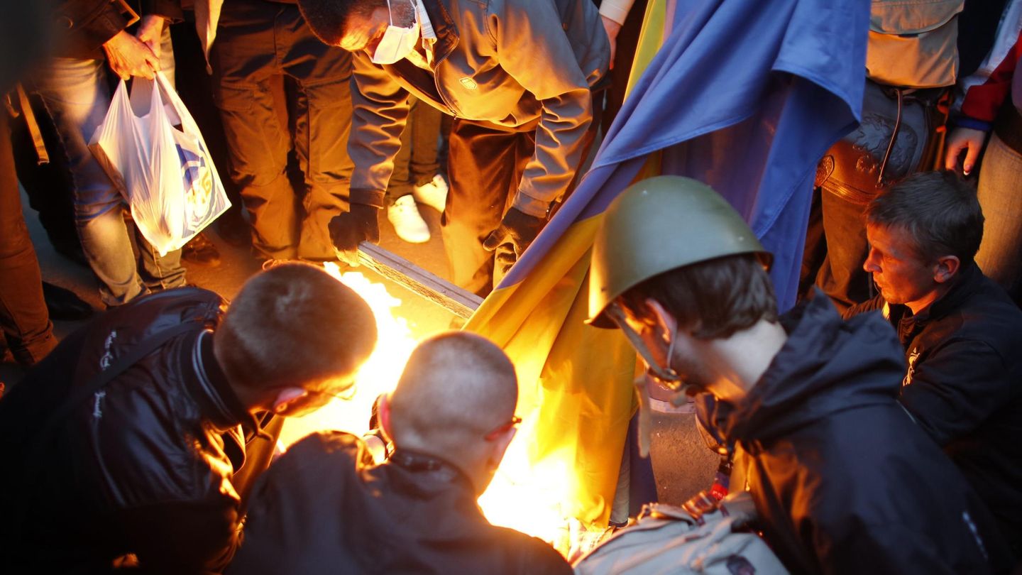 Manifestantes prorrusos queman una bandera de Ucrania en Donéstsk. (Reuters)
