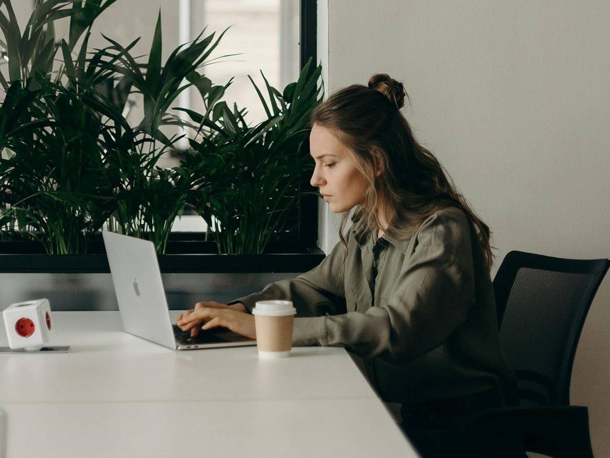 Foto: Una joven revisa su ordenador en una oficina | Pexels