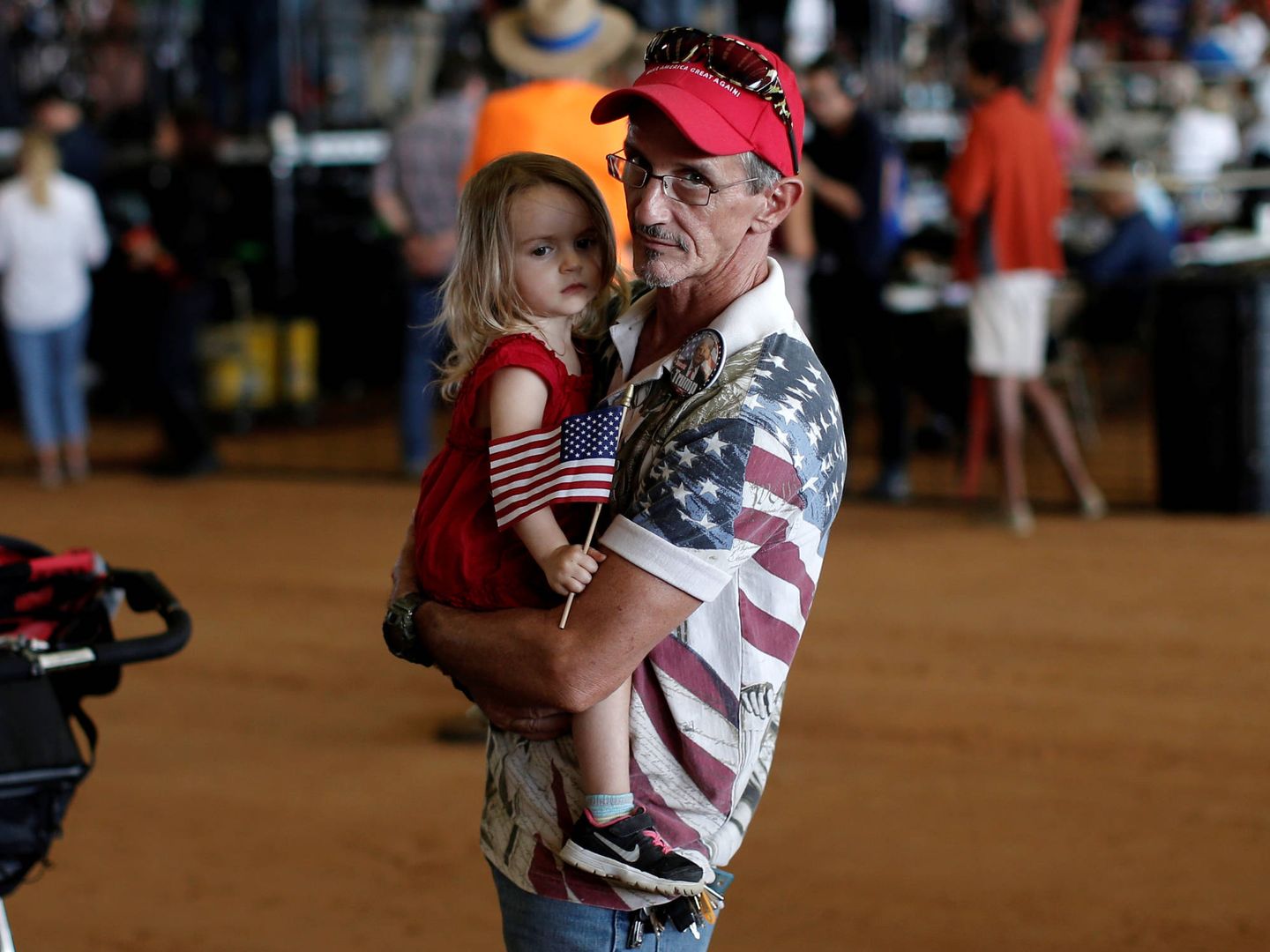 Steve Durand, de Ocala, Florida, sostiene a su hija durante un mitin de campaña de Donald Trump. (Reuters)