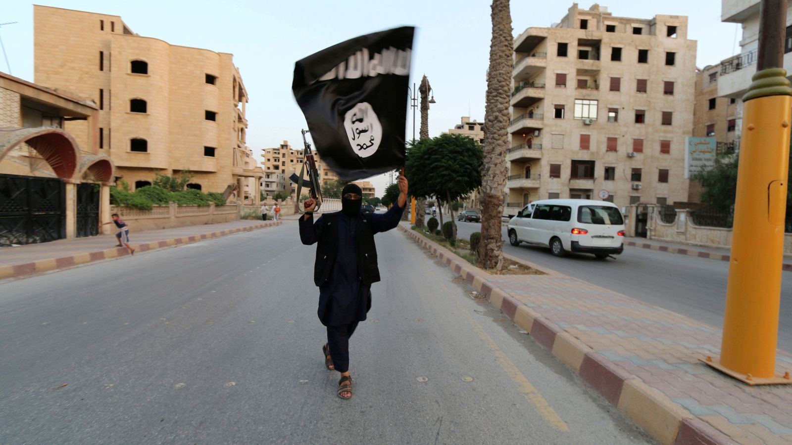 Foto: Un miembro del Estado Islámico de Irak y el Levante ondea una bandera en Raqqa, Siria. (Reuters)