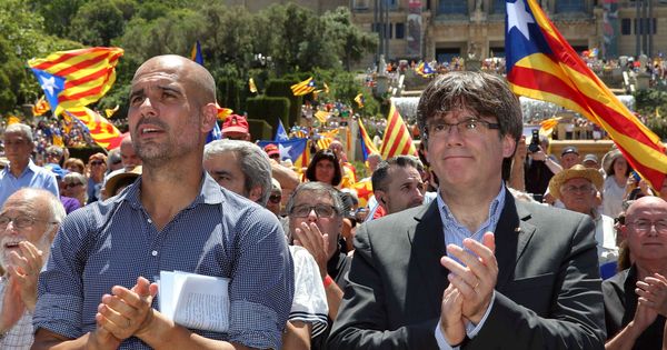 Foto: Carles Puigdemont y Pep Guardiola aplauden al finalizar un acto con el lema 'Referéndum es democracia'. (EFE)
