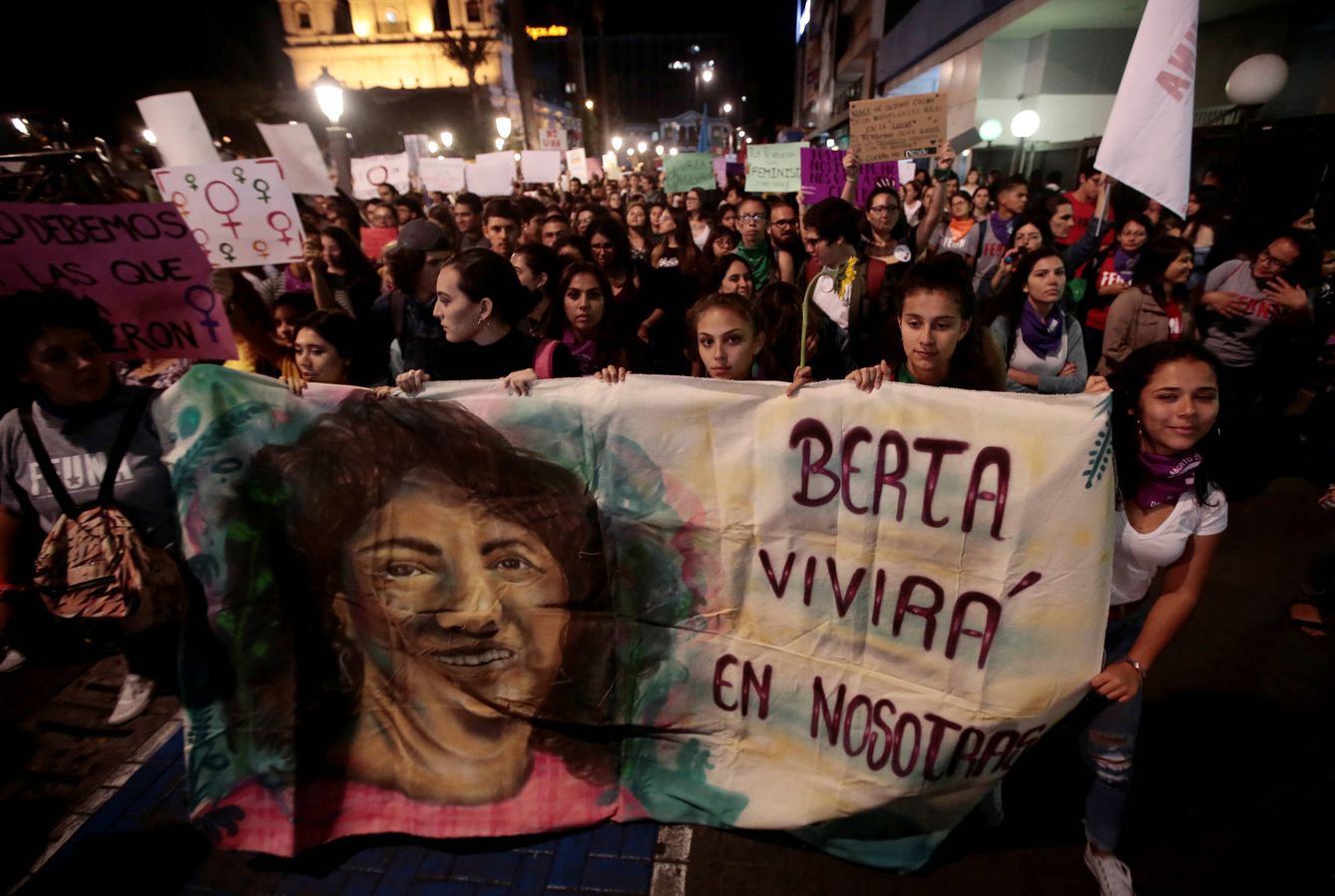 Mujeres sostiene una pancarta con la imagen de la líder ecologista Berta Cáceres, asesinada en 2016. (Reuters)