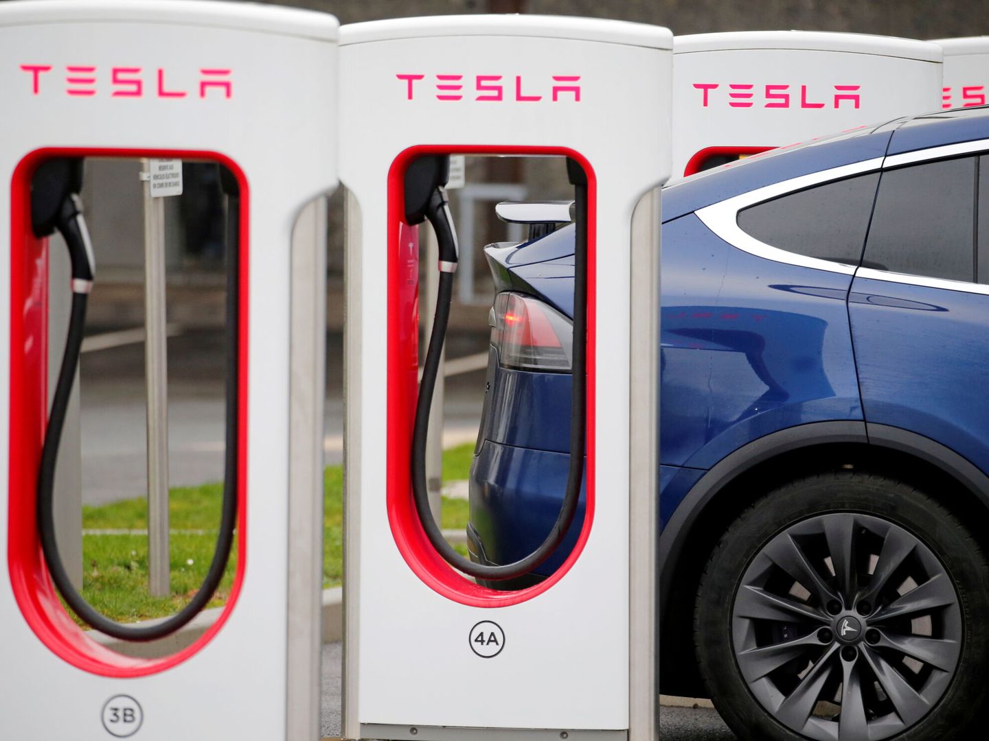 Conductor recargando la batería de su Tesla (Reuters)