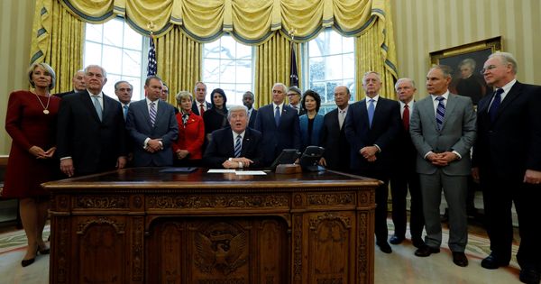 Foto: Donald Trump firma una orden ejecutiva rodeado por los miembros de su gabinete, el 13 de marzo de 2017. (Reuters)