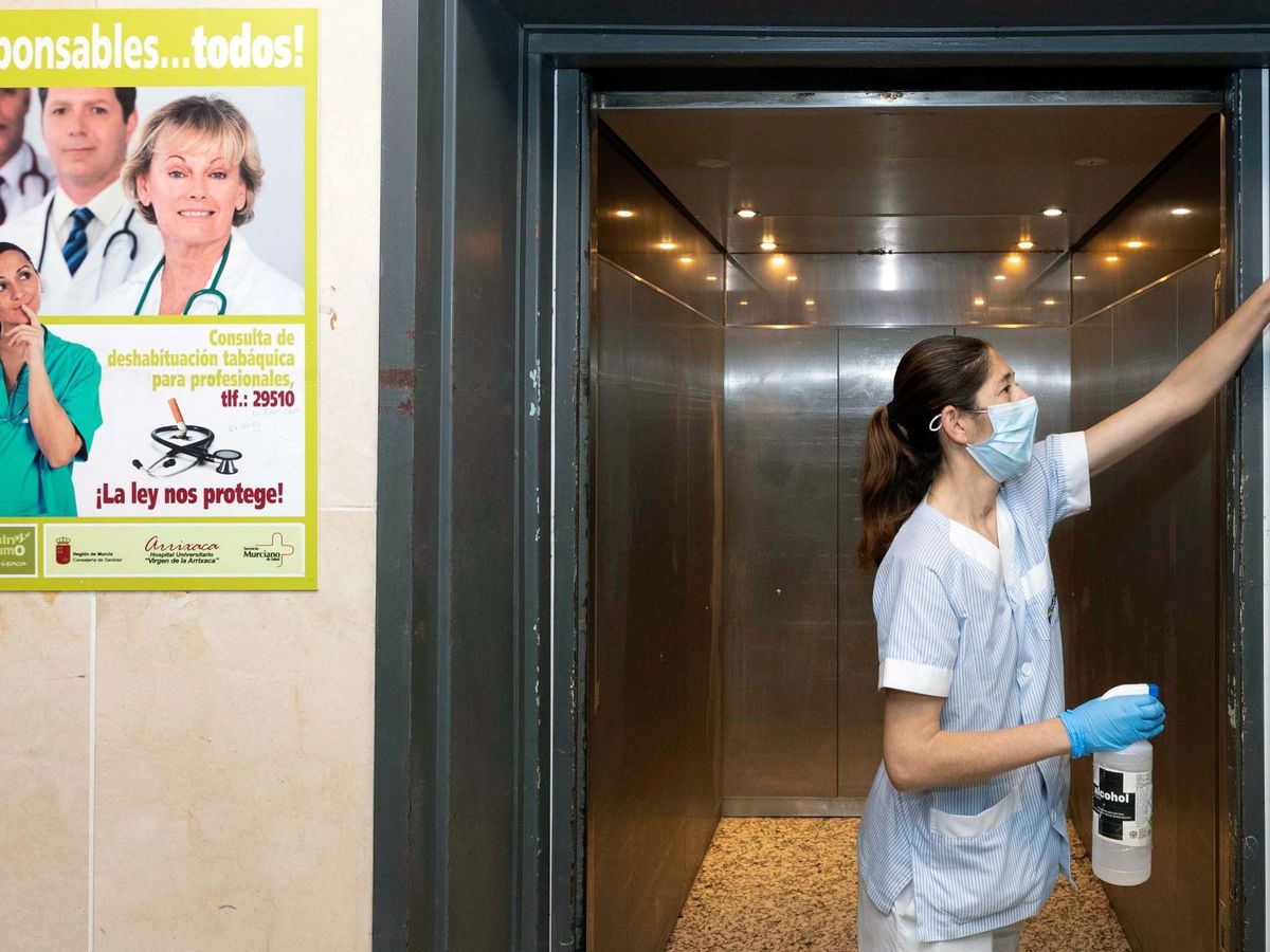 Foto: Una limpiadora desinfecta el ascensor del Hospital Virgen de la Arrixaca. (EFE)