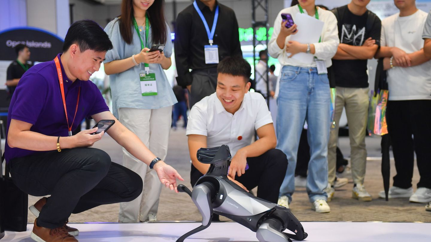 Visitantes a la Conferencial Mundial de Computación 2023 en la localidad china de Changsha interaccionan con un robot perro. EFE / XINHUA CHEN ZEGUO