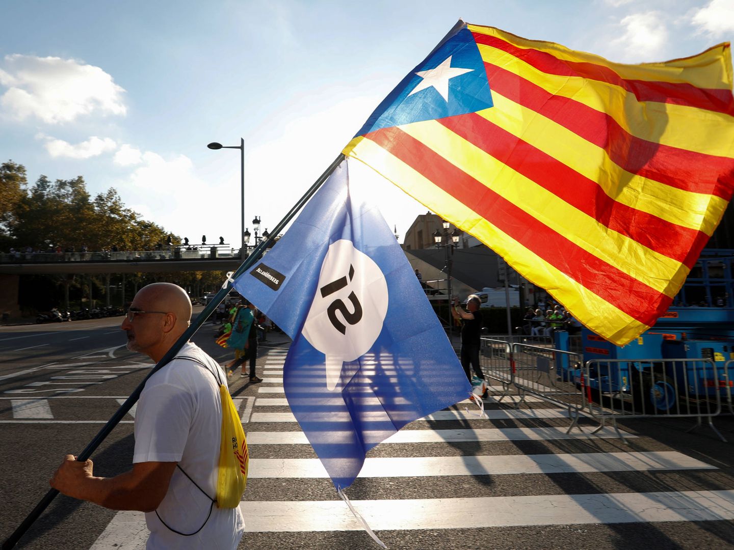 Un hombre porta la estelada y una bandera del 'Sí' en Barcelona. (Reuters) 