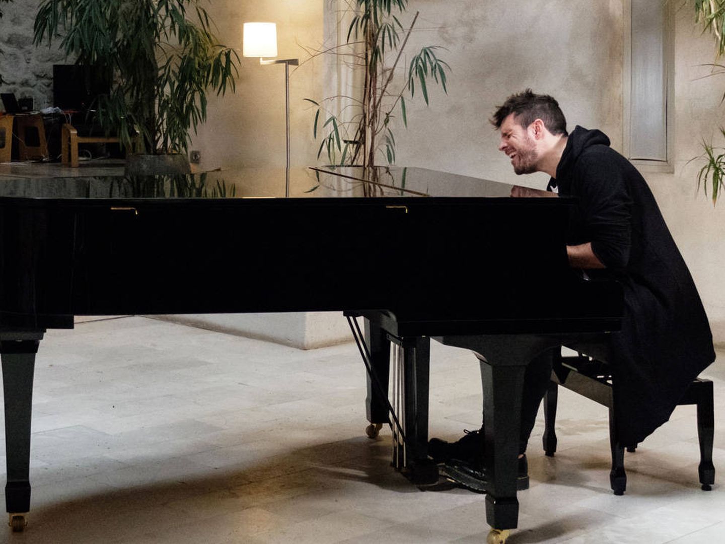 Pablo López toca el piano en un salón de su casa. (Mediaset)