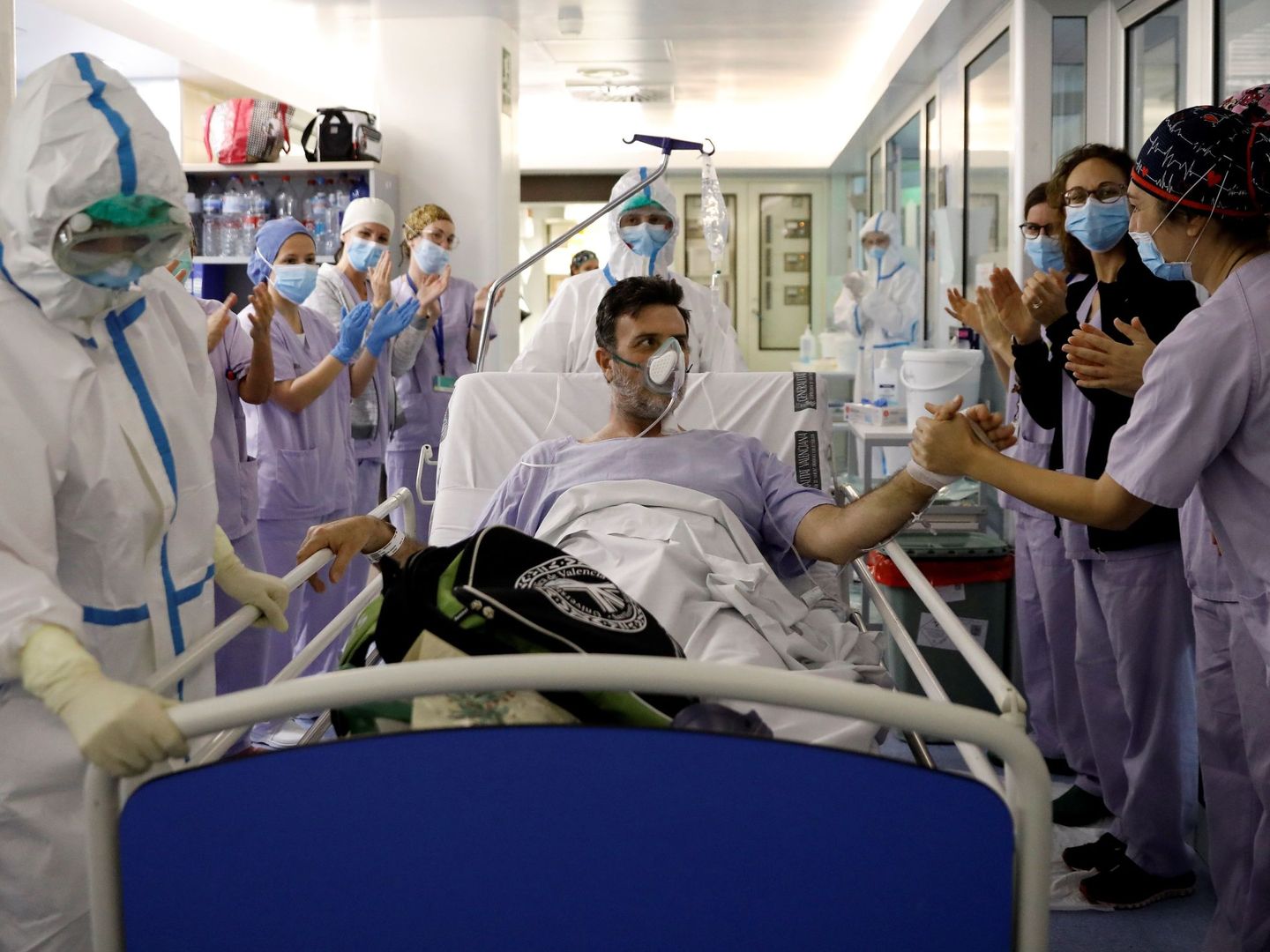 Sanitarios despiden a un paciente que ha sido dado de alta tras varios días en la UCI en Valencia. (EFE)