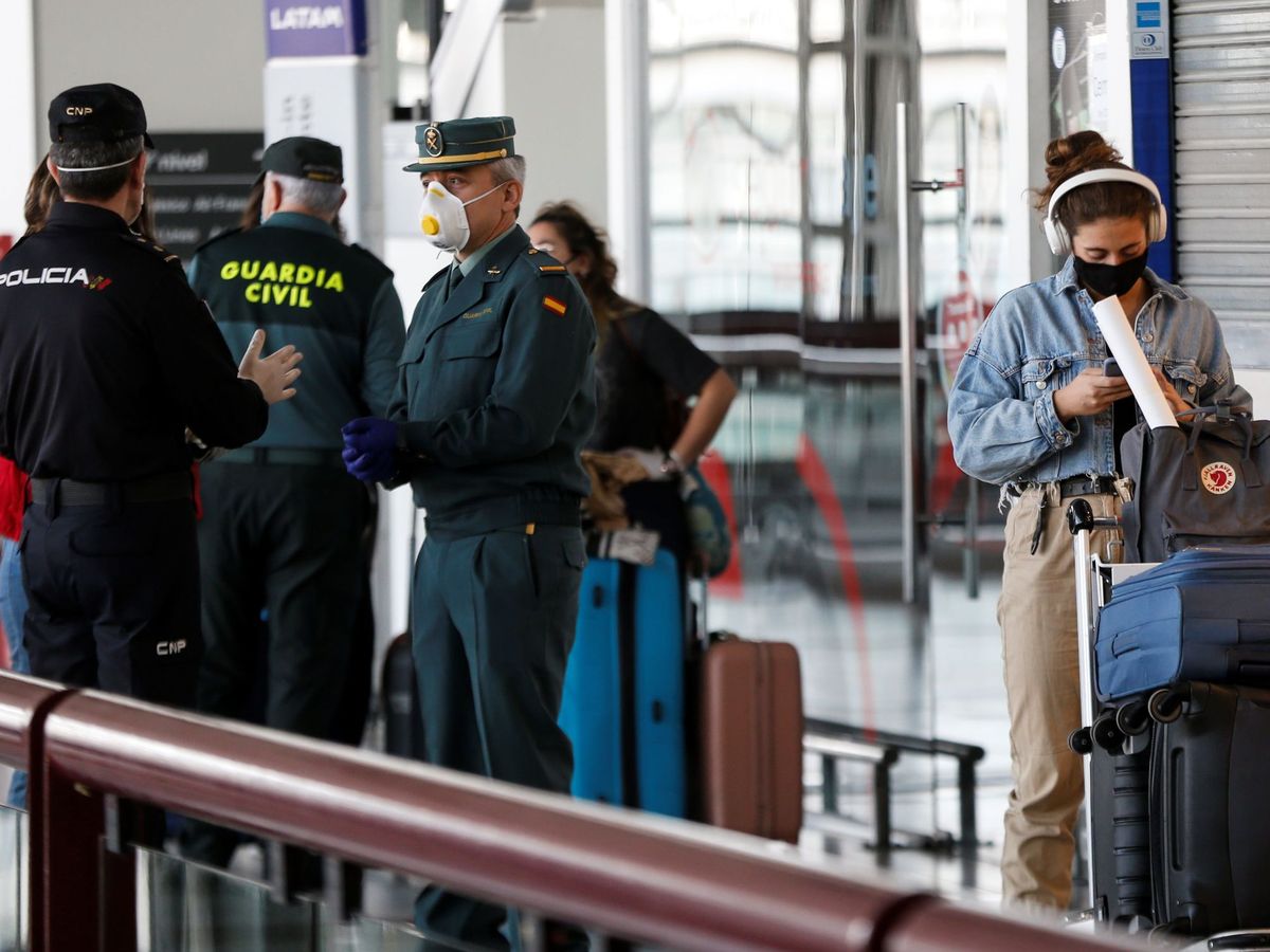 Foto: Un grupo de viajeros, junto a agentes de la Policía Nacional y la Guardia Civil de España. (EFE)