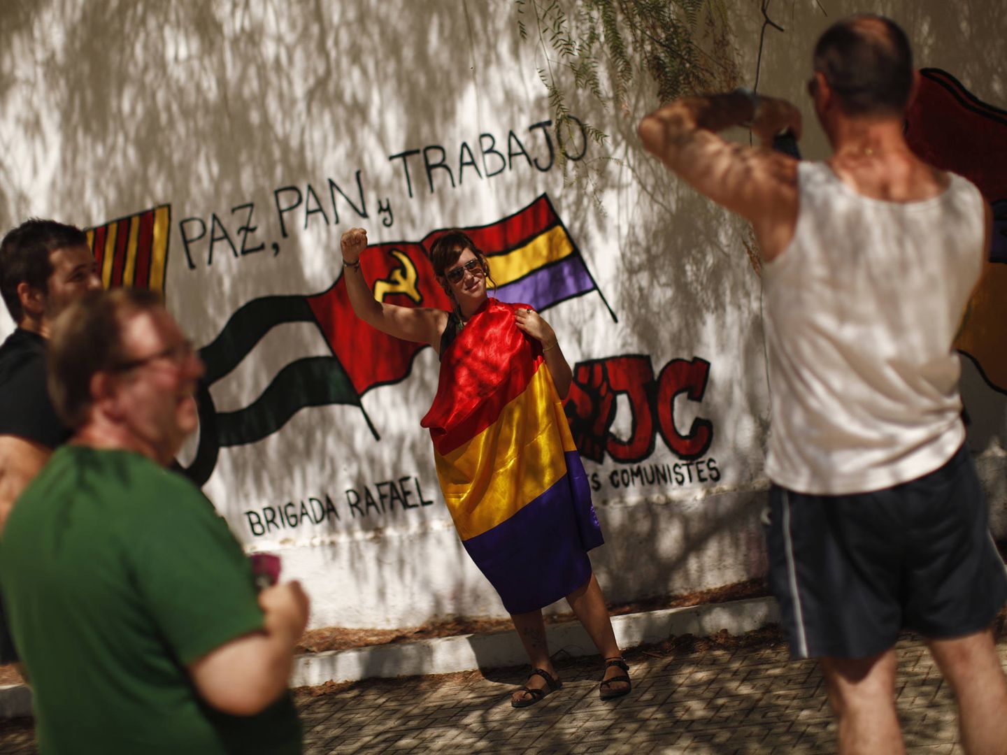 Un grupo de turistas posa para un foto en uno de los múltiples murales pintados en Marinaleda. (Reuters)