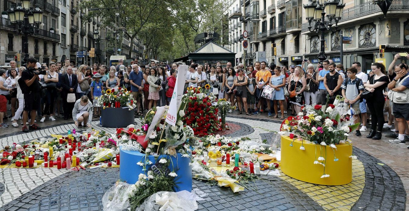 Grupos de personas depositan flores en el mosaico de Miró en Las Ramblas en recuerdo de las victimas de los atentados del 17-A en Barcelona y Cambrils. (EFE)