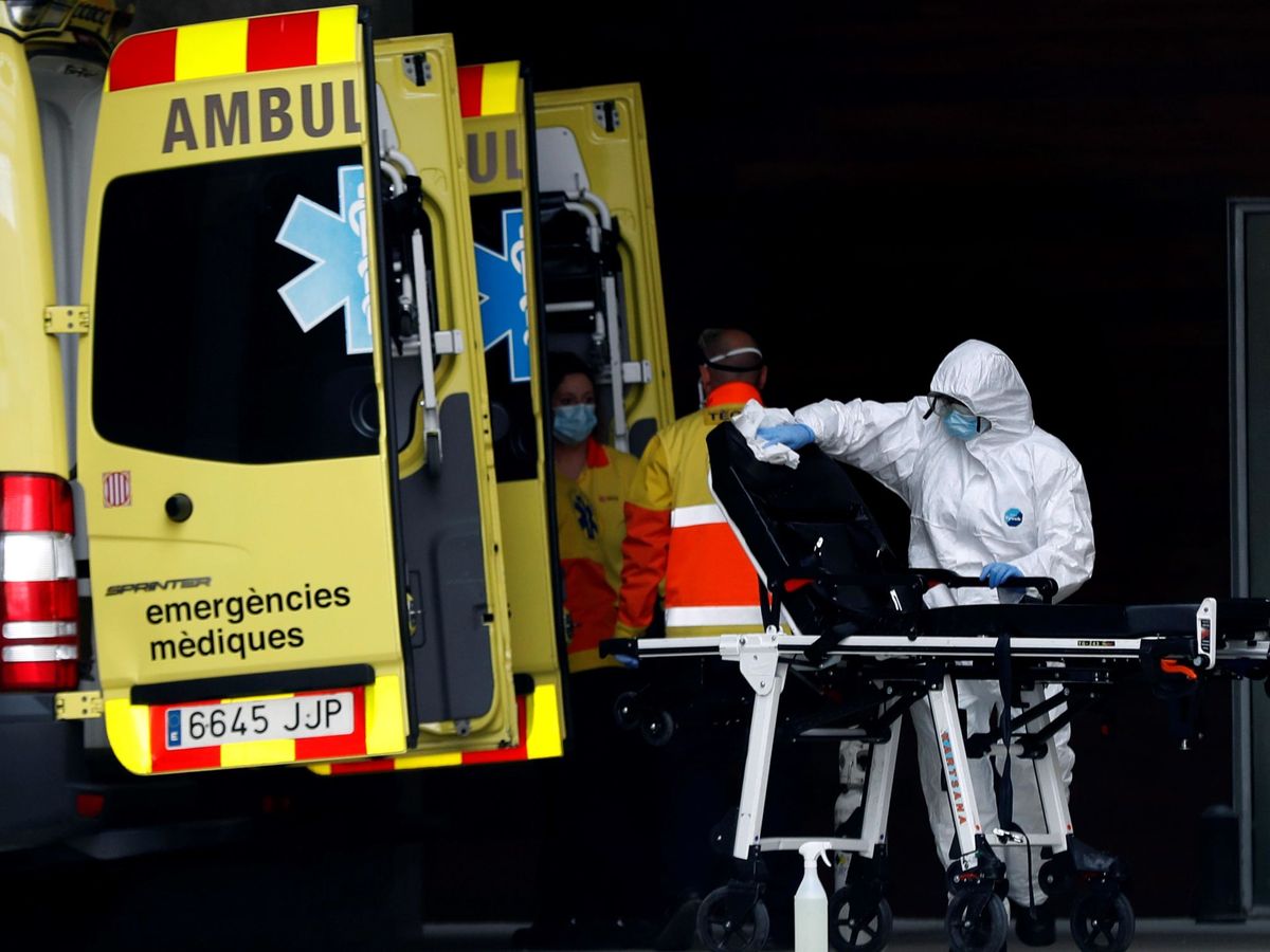 Foto: Un técnico sanitario desinfecta la camilla de una ambulancia en la entrada de urgencias del Hospital de Bellvitge. (EFE)