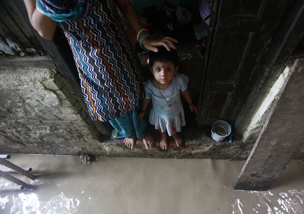 Foto: Una niña observa al fotógrafo desde el umbral de su casa en Nueva Delhi (Reuters). 