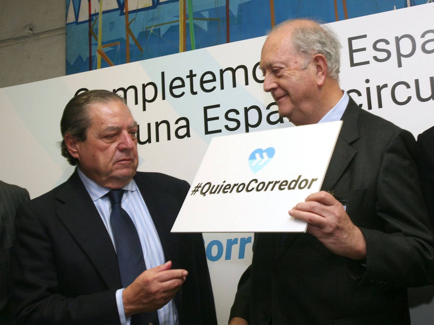 Vicente Boluda (i), y el presidente del Cercle d'Economia, Juan José Bruguera (d), posan con letreros reivindicativos del Corredor Mediterráneo en un acto en Tarragona. (EFE)