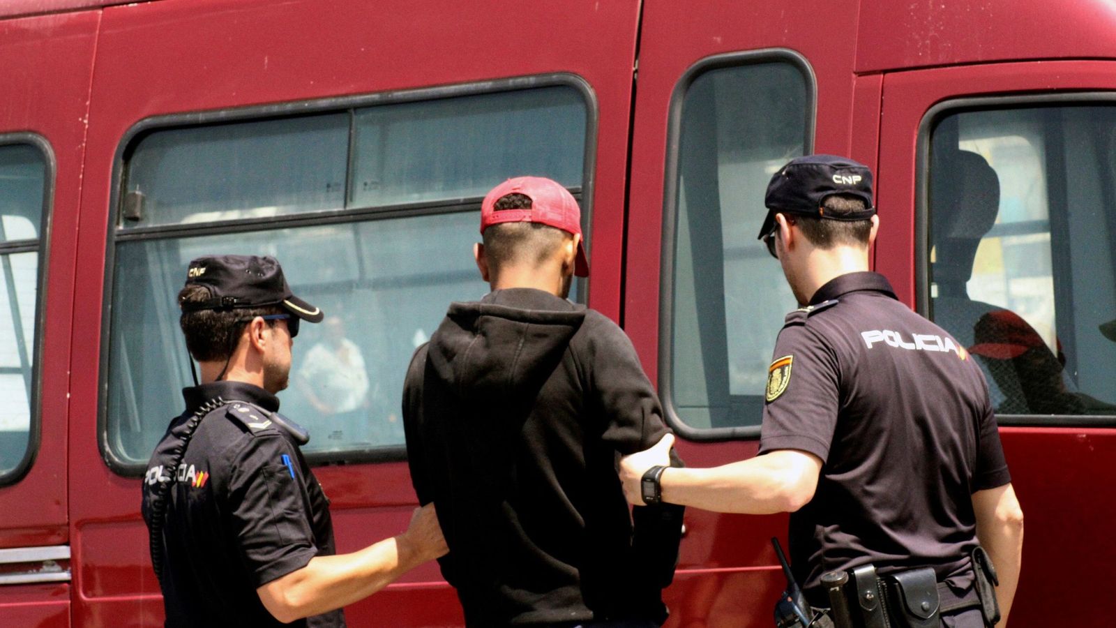 Foto: Agentes de la Policía Nacional detienen a un inmigrante en Ceuta el pasado mes de agosto. (EFE)