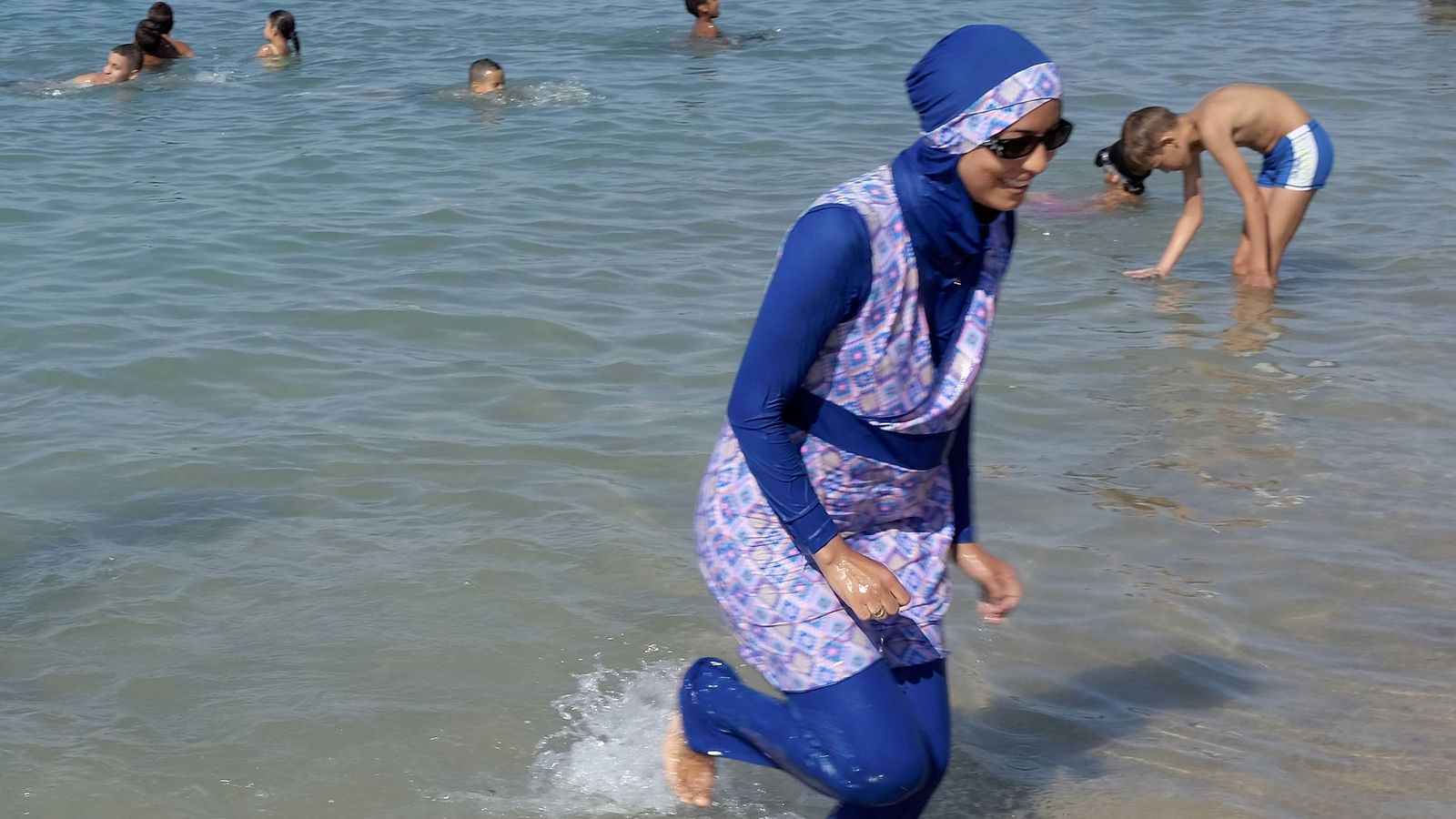 Foto: Una mujer con burkini sale del agua en una playa de Marsella. (Reuters)