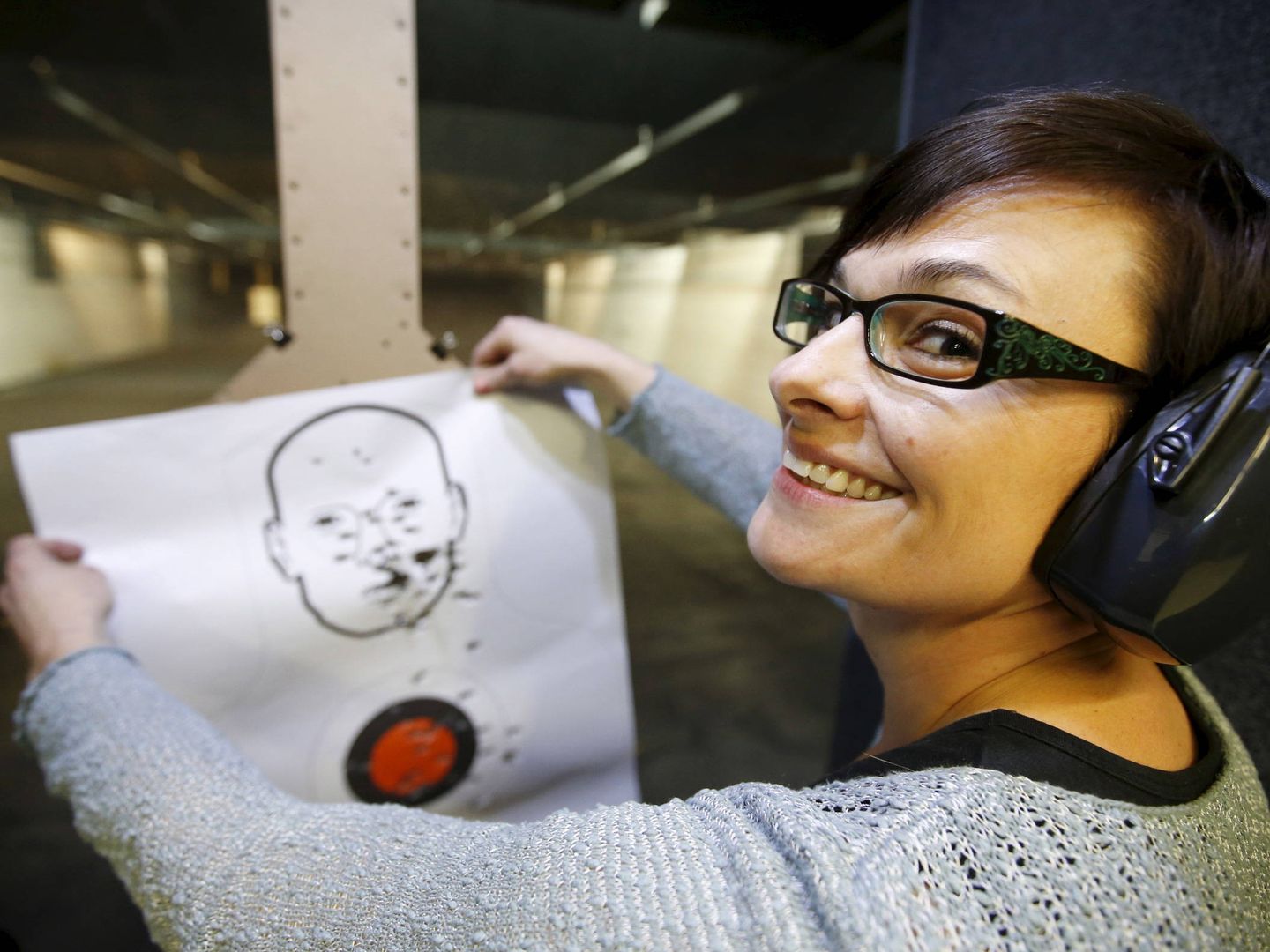 Jessie Palmieri, nueva propietaria de una pistola, sostiene una diana mientras practica en una galería de tiro en Springville, Utah, en diciembre de 2015. (Reuters) 