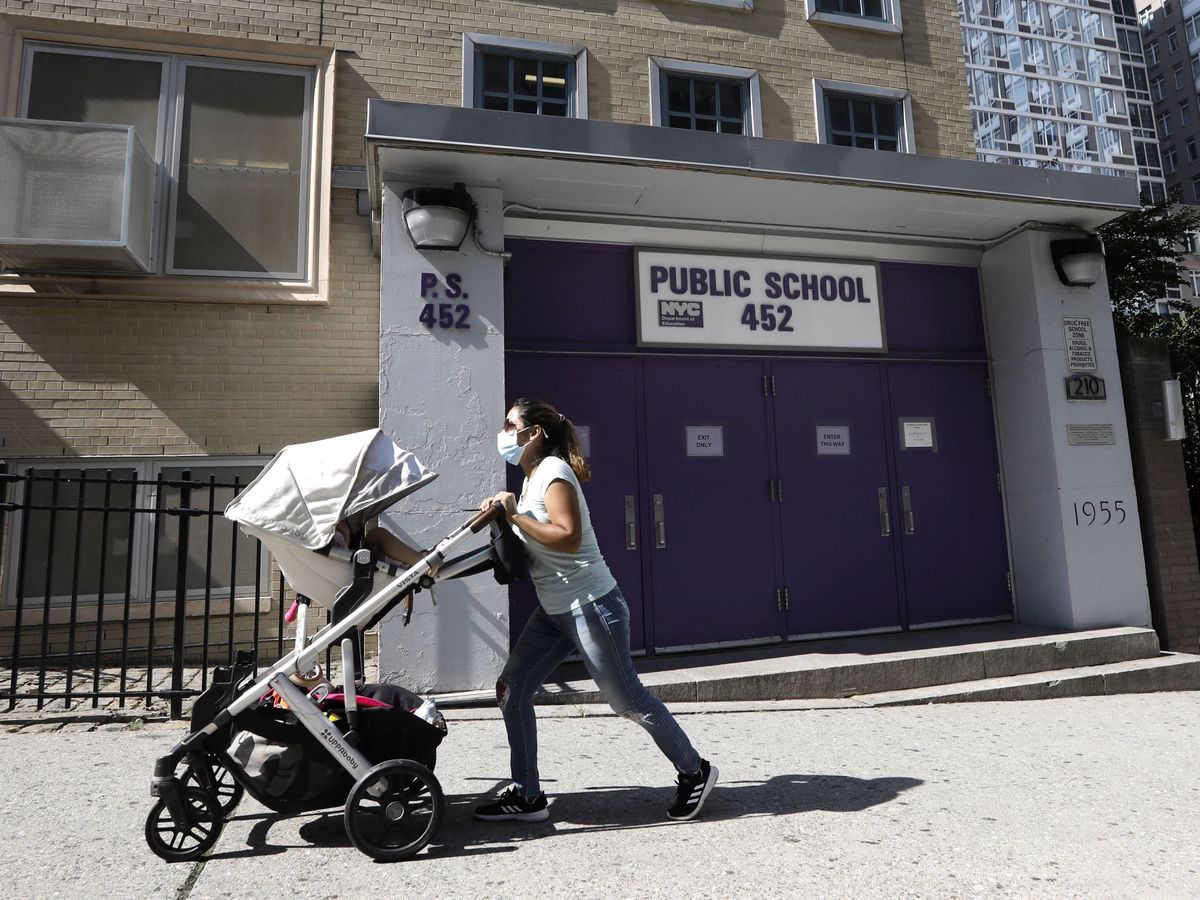 Foto: Una mujer con un carrito pasa frente a un colegio público en Nueva York. (EFE)