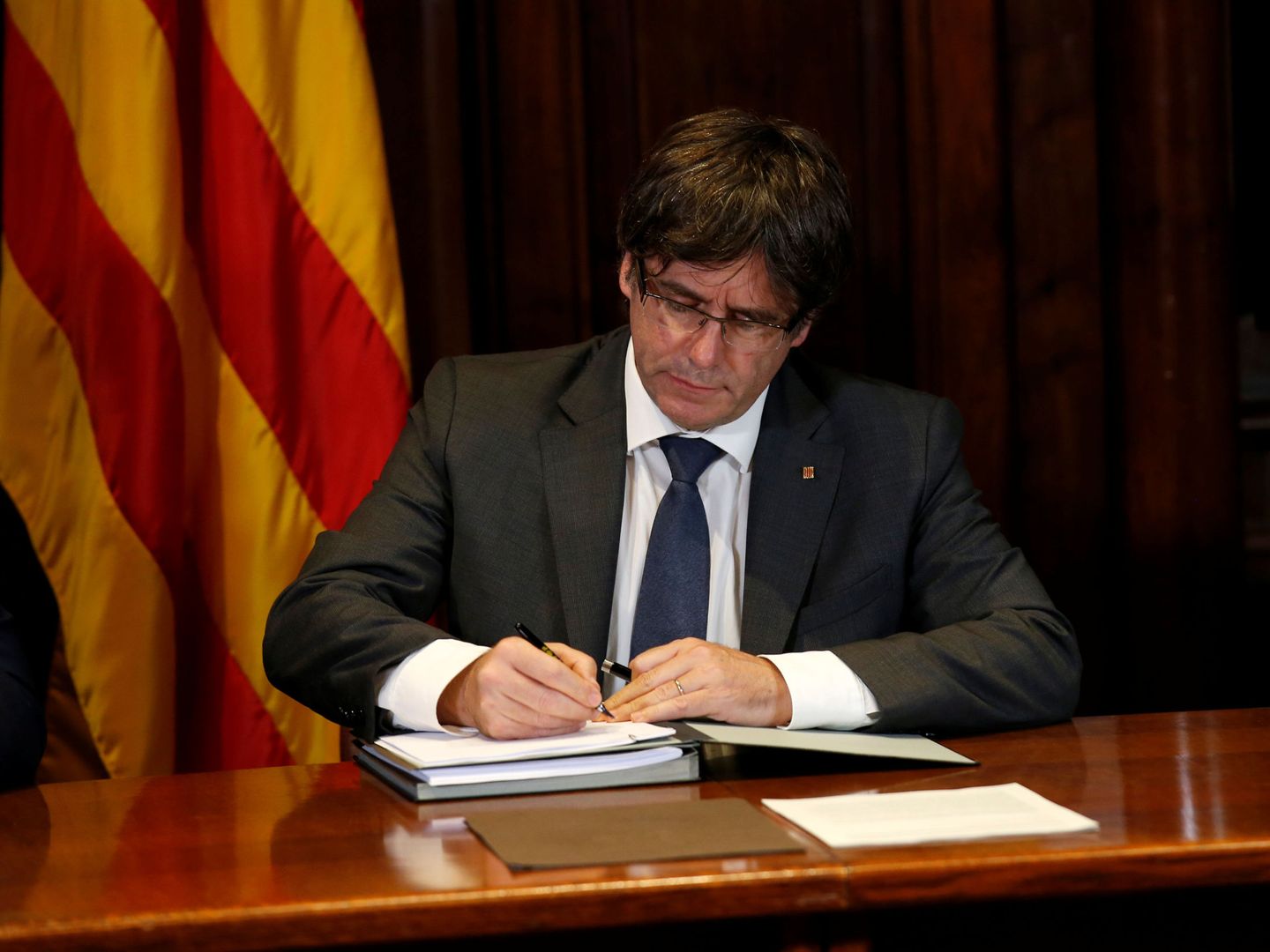 Carles Puigdemont firma la ley del referéndum, declarada ilegal por el Tribunal Constitucional. (Reuters)