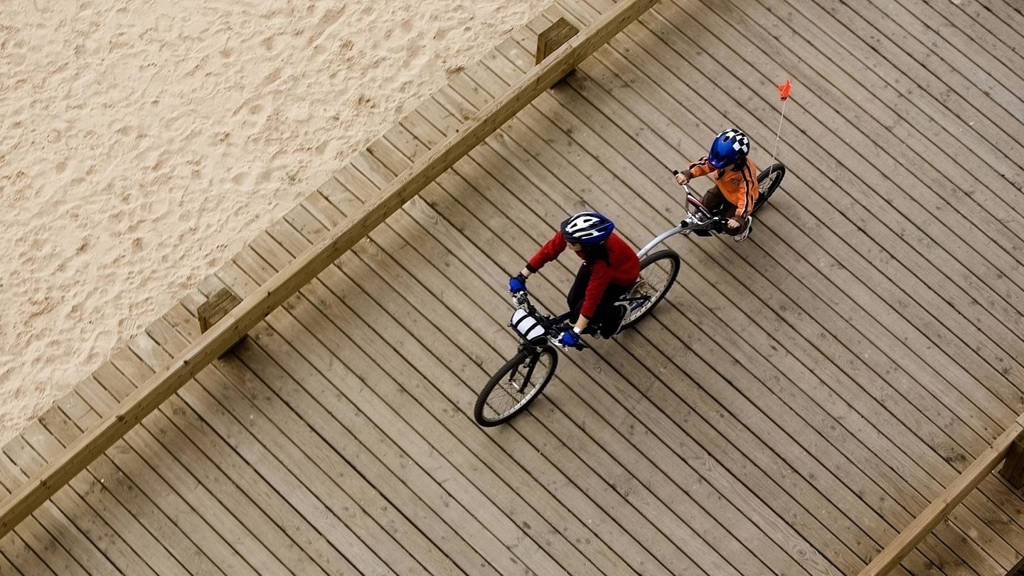 Una madre y su hijo montan en bicicleta junto al mar en Portimao, en el sur de Portugal. (Reuters) 