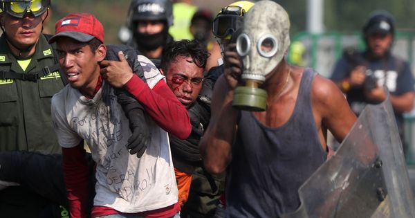 Foto: Un herido es socorrido durante los enfrentamientos con la Guardia Nacional Bolivariana, este lunes, en el puente Simón Bolívar. (EFE)