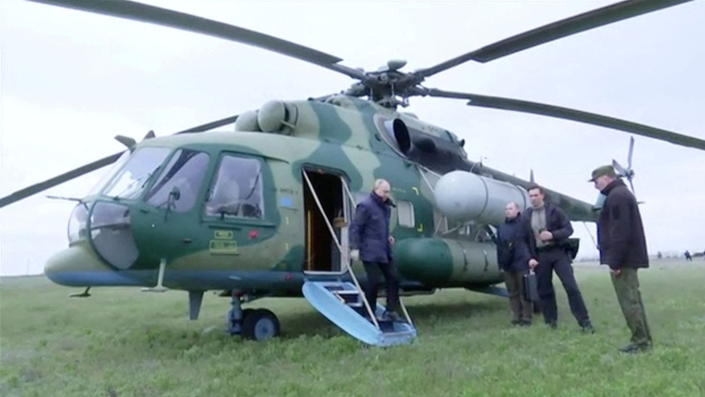 Russian President Vladimir Putin disembarks a helicopter as he visits the headquarters of the 