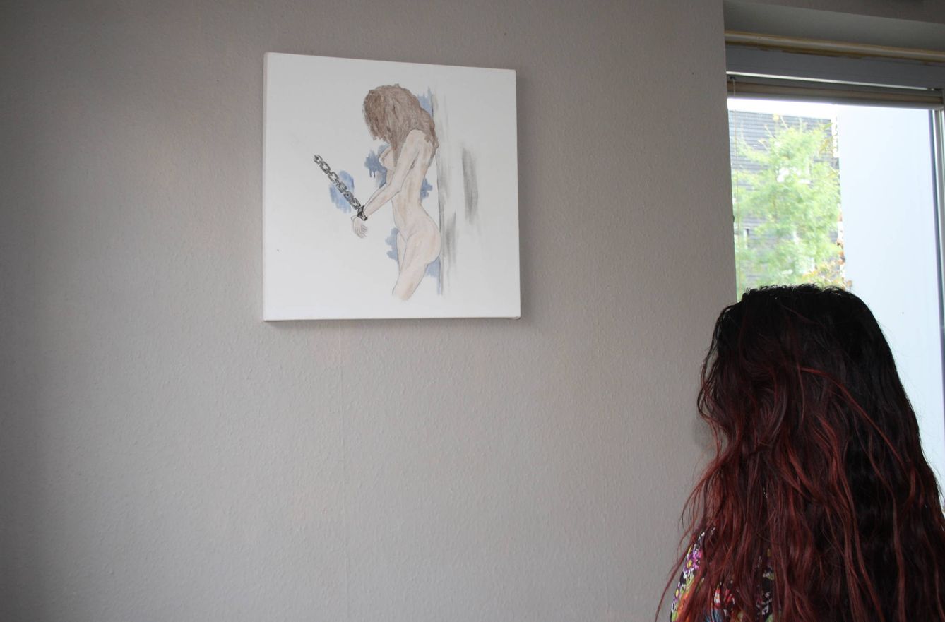 Alejandra de espaldas a su dibujo, que denuncia el proxenetismo escolar en Holanda. 