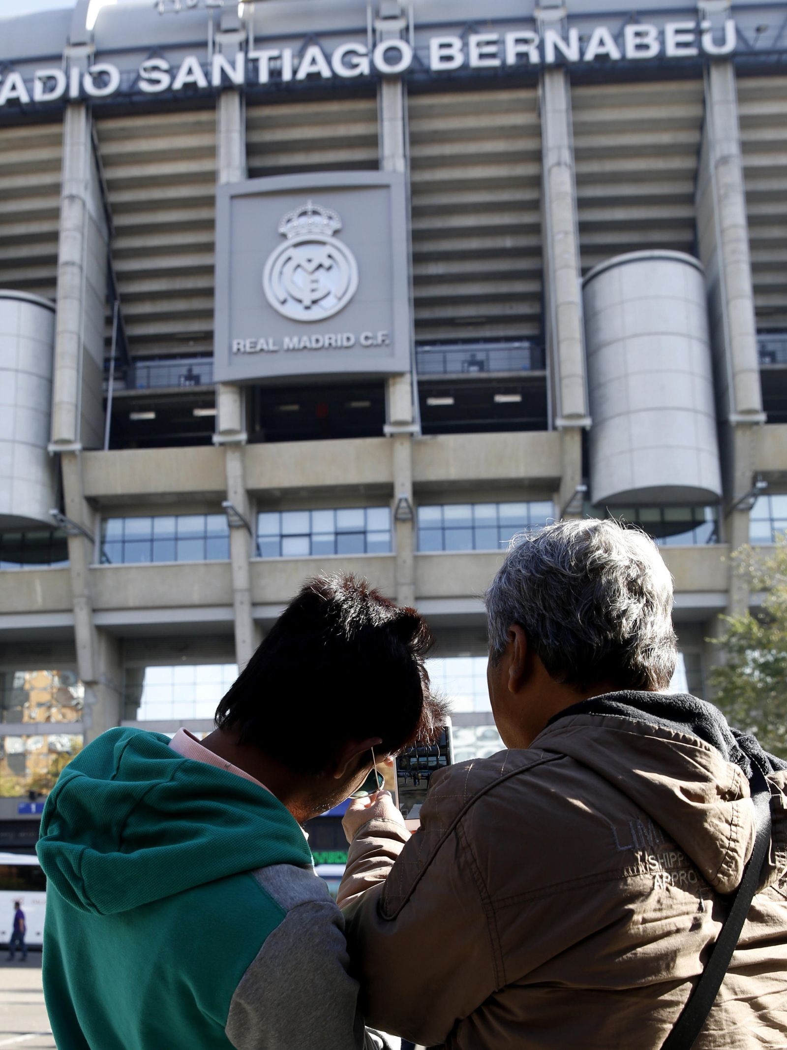 Dos personas hacen una foto a la fachada del Santiago Bernabéu. (EFE)
