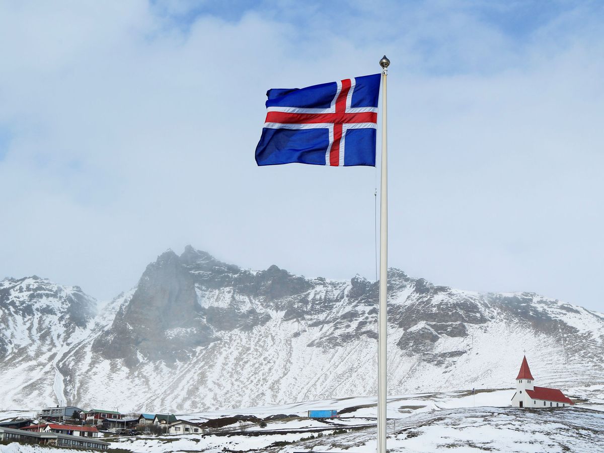 Foto: Bandera nacional de Islandia y una pequeña inglesia en Vik, Islandia (Reuters)