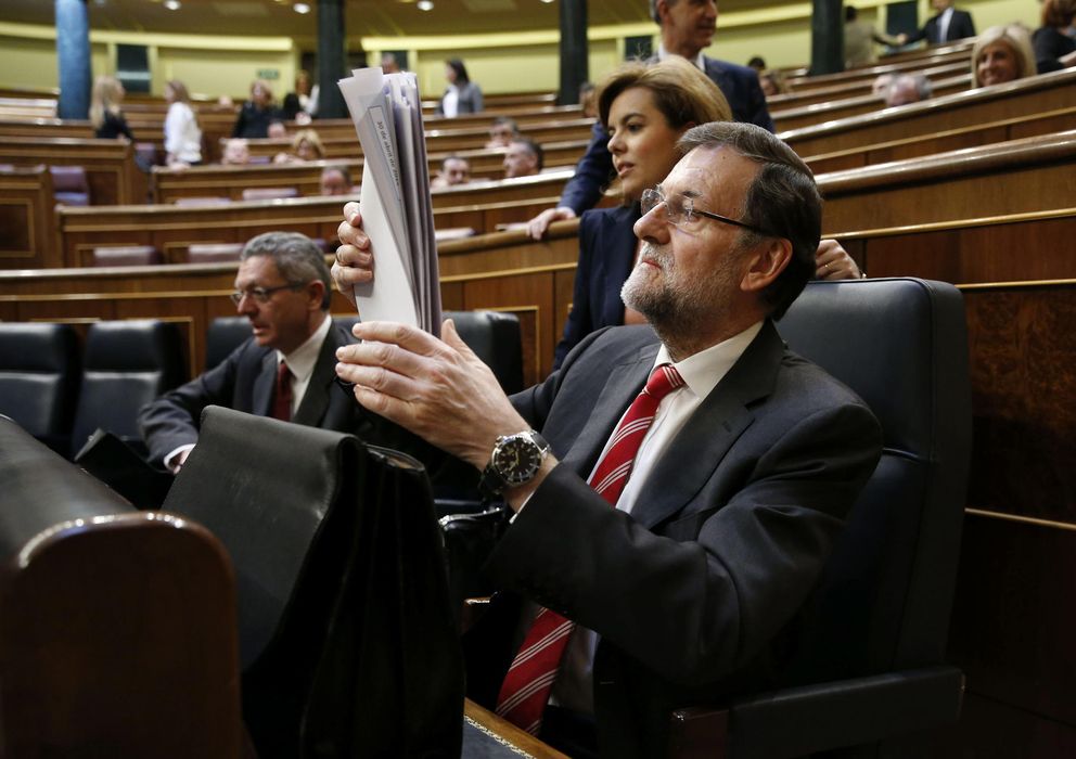 Foto: El presidente del Gobierno, Mariano Rajoy (d), consulta unos documentos en el Congreso. (EFE)
