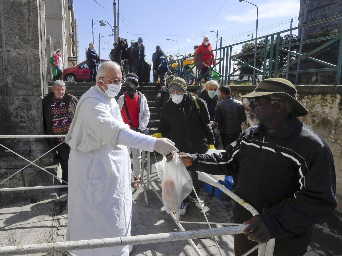Foto: El padre Francesco Sorrentino distribuye alimentos a los pobres en Nápoles. (EFE)